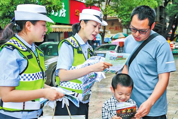 民警走上街头向市民发宣传资料，倡导文明出行。.jpg